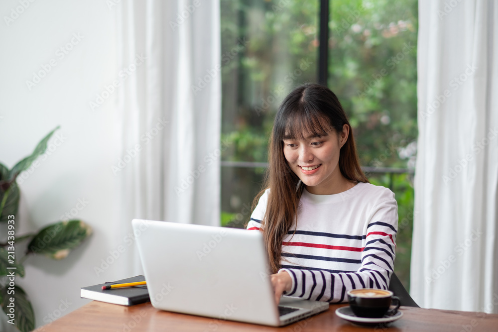 Happy asian woman using on laptop computer while working near window at cafe restaurant,Digital co working space lifestyle.influencer blogger review.working outside office Happy asian woman using on laptop computer while working near window at cafe restaurant,Digital co working space lifestyle.influencer blogger review.working outside office