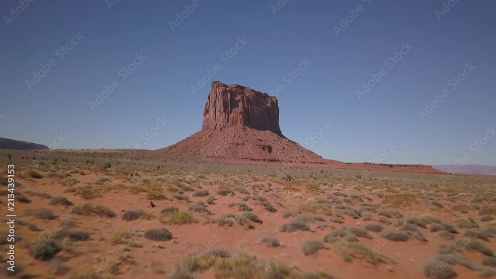 Western Monument - Red rock formation in Arizona, desert with bushes - Fast low altitude flight Western Monument - Red rock formation in Arizona, desert with bushes - Fast low altitude flight