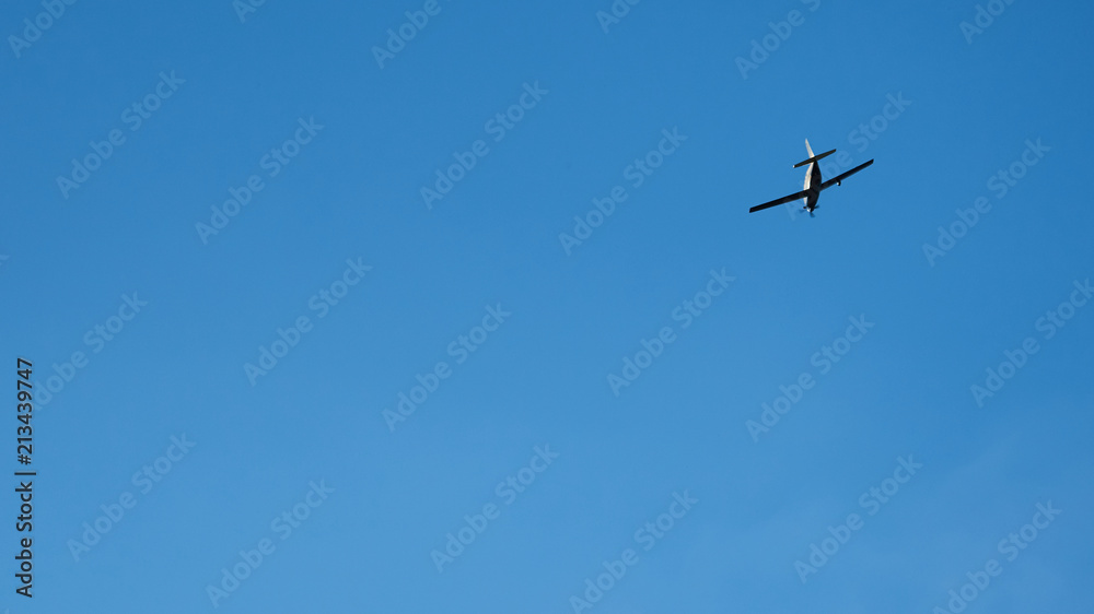 Propeller plane flying across blue sky Propeller plane flying across blue sky