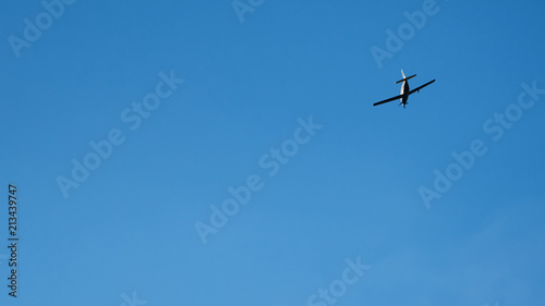 Propeller plane flying across blue sky