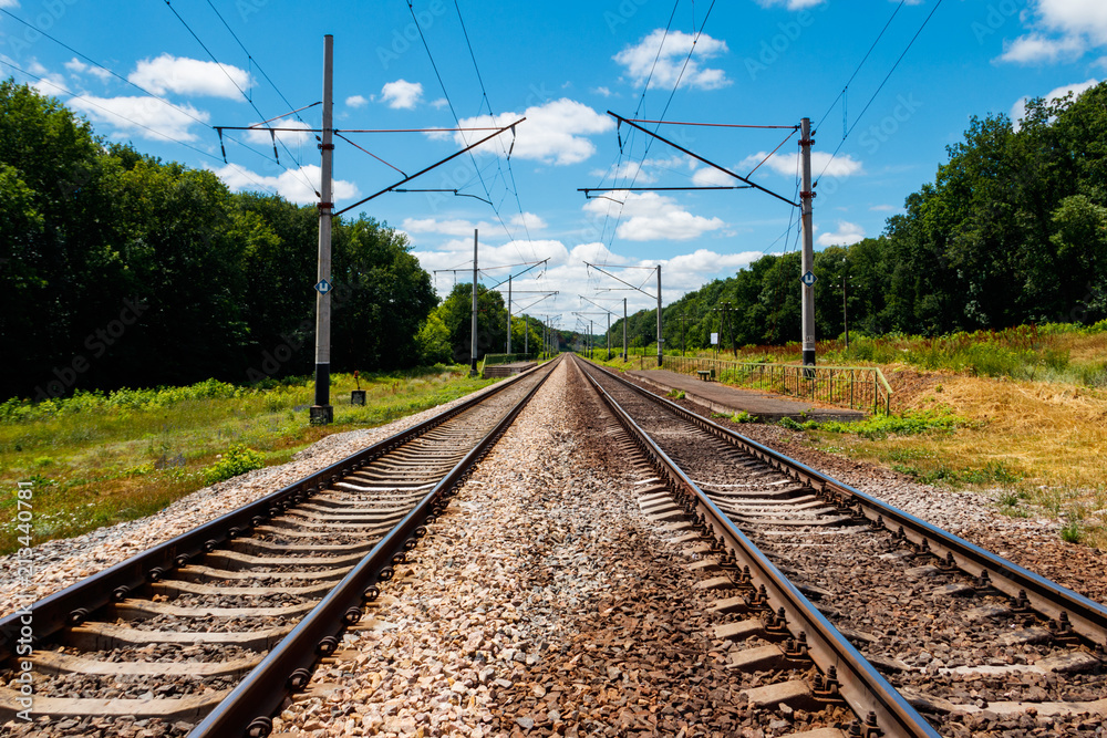 Scenic railroad in rural area and blue sky with white clouds in summer