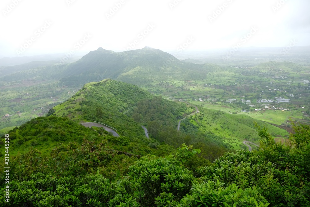 Green landscape surrounded by hills, mountains in monsoon season 
