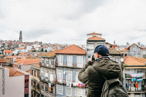 A professional travel photographer or tourist photographs a beautiful cityscape in Porto in Portugal. Professional occupation or hobby