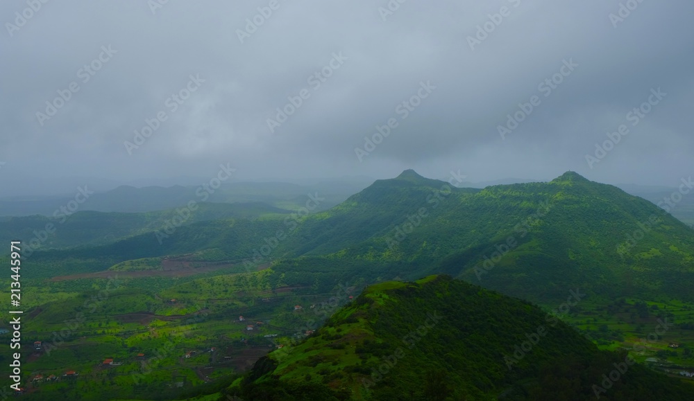 Fototapeta premium Green landscape surrounded by hills, mountains in monsoon season 