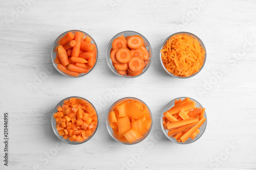 Flat lay composition with cut carrots on wooden background