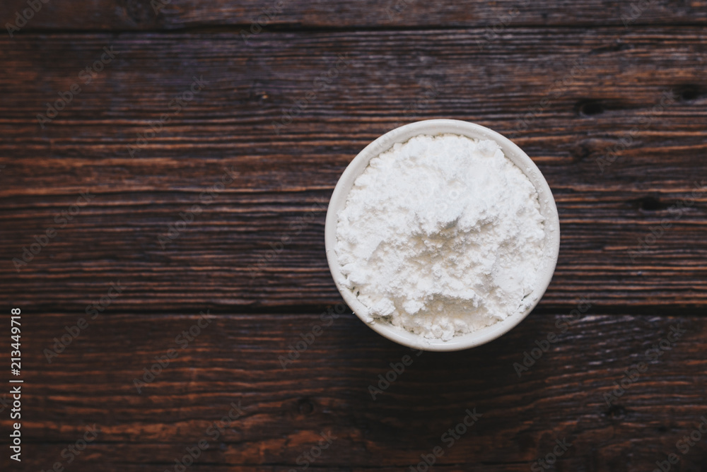Sugar powder in a bowl on the wooden surface Sugar powder in a bowl on the wooden surface