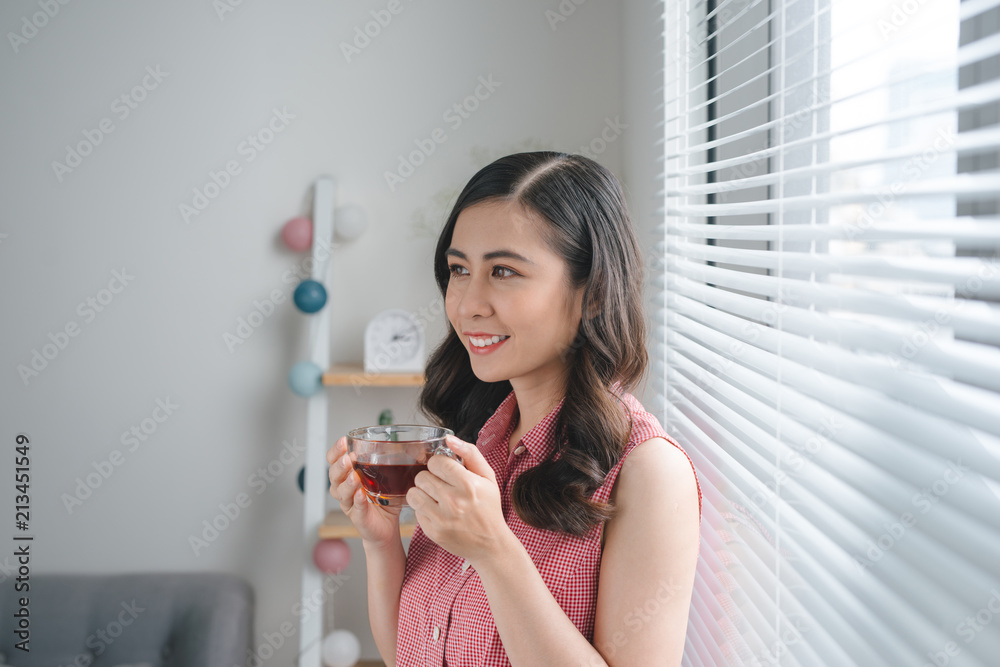 Smiling young woman drinking coffee or tea while work or study at home. Smiling young woman drinking coffee or tea while work or study at home.