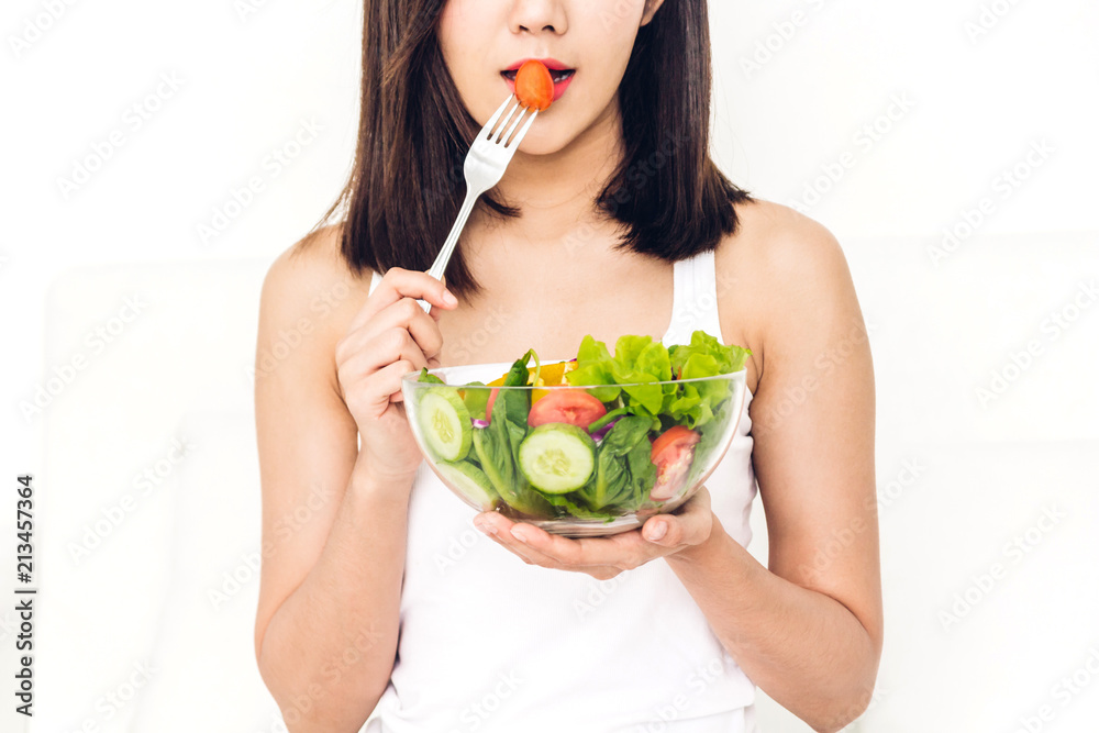 Happy woman eating and showing healthy fresh salad in a bowl.dieting concept.healthy lifestyle with green food Happy woman eating and showing healthy fresh salad in a bowl.dieting concept.healthy lifestyle with green food