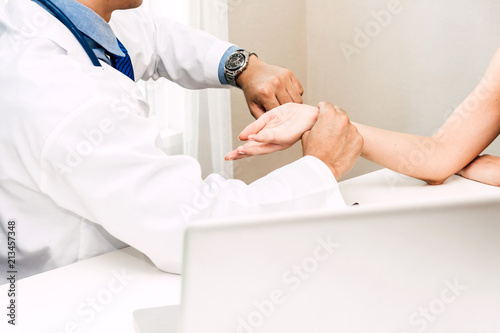 Doctor checking female patient's pulse in hospital.healthcare and medicine