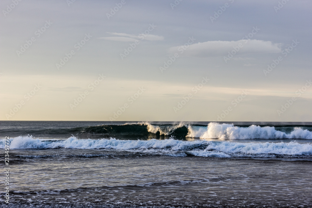 Sunset light softly touching breaking waves on winter day in Arrietara beach, Basque Country. Tide, swimming conditions concepts