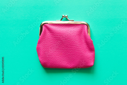 Pink wallet on turquoise background . Close up. Top view