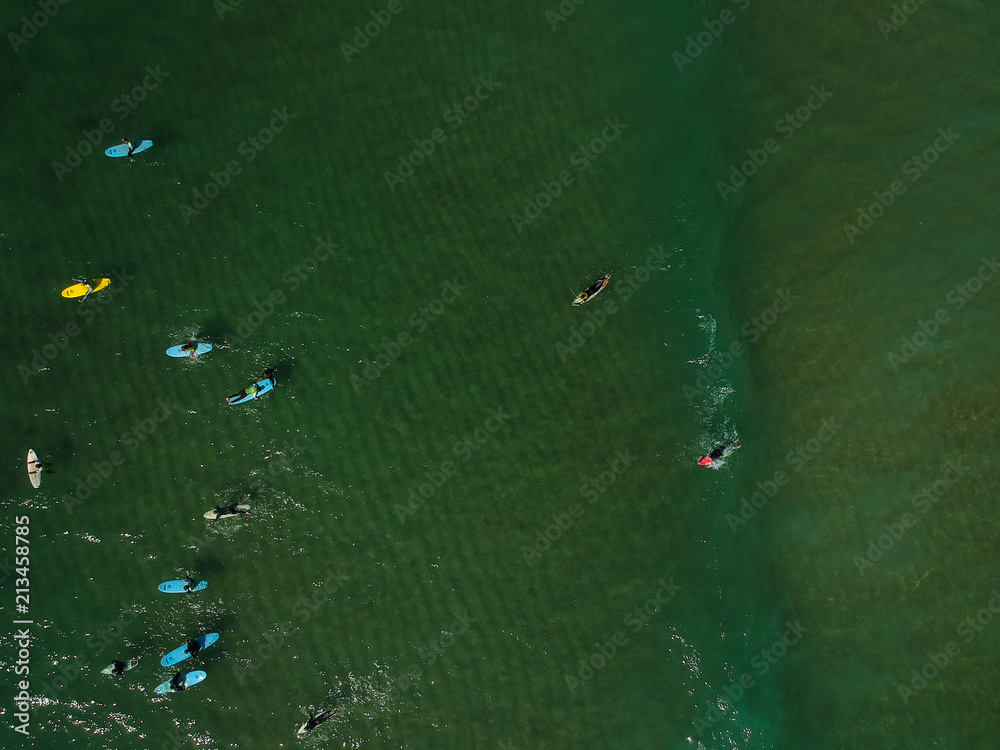 Aerial view of surfers in the ocean on a summer day. Surf Spot on the Portuguese coastline. Drone shot. Aerial view of surfers in the ocean on a summer day. Surf Spot on the Portuguese coastline. Drone shot.