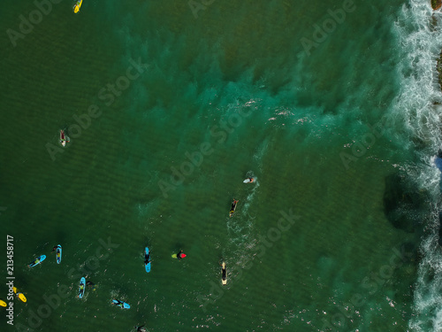 Aerial view of surfers in the ocean on a summer day. Surf Spot on the Portuguese coastline. Drone shot. © nvphoto