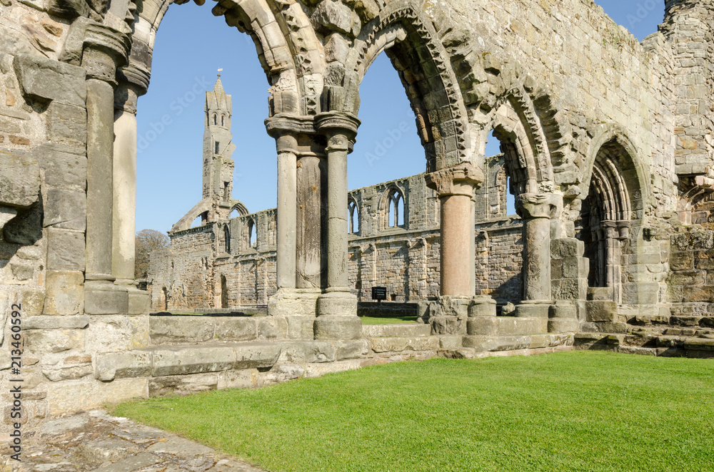 Looking through a series of arches at the ruined St Andrews cathedral on a bright, sunny day. St Andrews, Fife, Scotland.