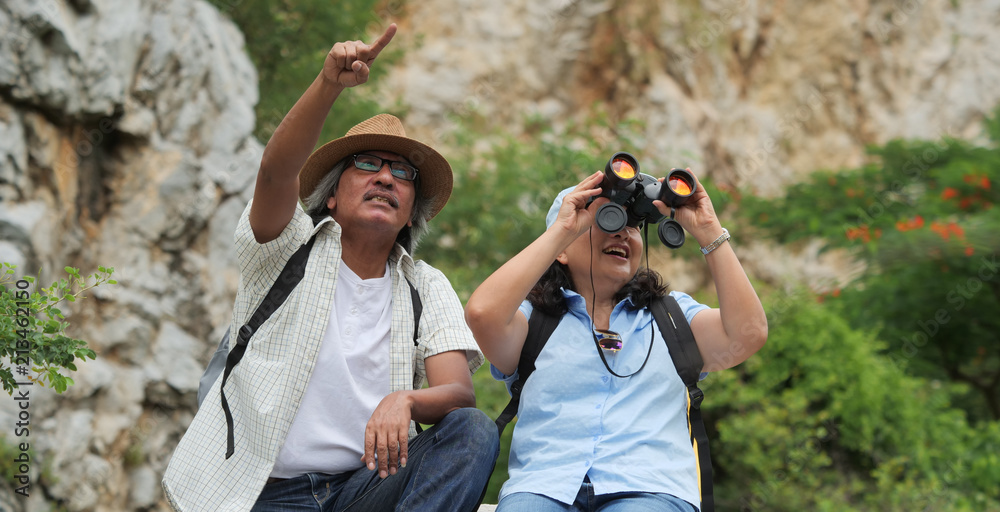 Banner of senior couple travel on a summer vacation.they are holding hands and hiking together.