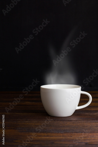 White coffee cup on plate with smoke
