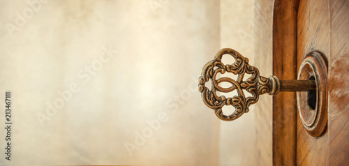 Old key in keyhole, macro shot. Retro style. Concept and Idea for History, business, security background. Write Your Text Here.