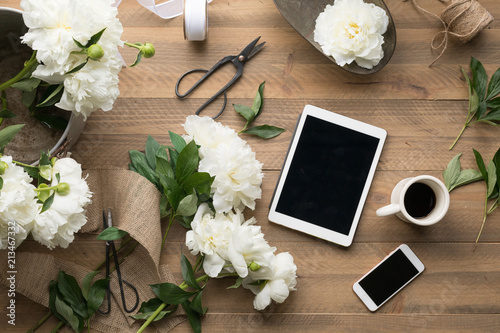 Flatlay of tablet smart phone and floral supplies photo