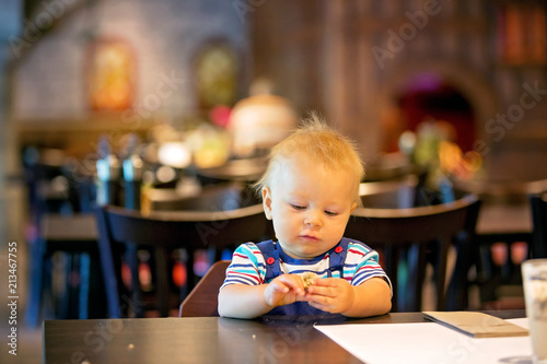 Little boy, child, enjoying breakfast in hotel restaurant