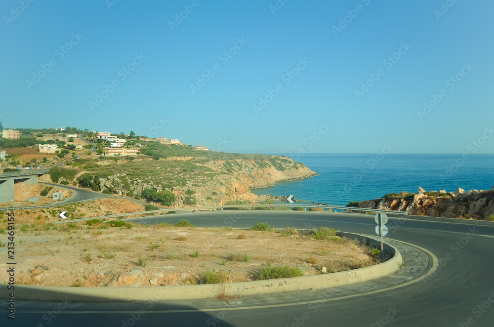 A winding asphalt road along the sea coast in Greece A winding asphalt road along the sea coast in Greece