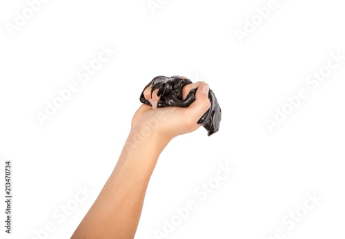 Hand squeezing black slime. Isolated on white background.