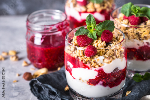 Yogurt parfafait with granola and raspberries in glass. photo