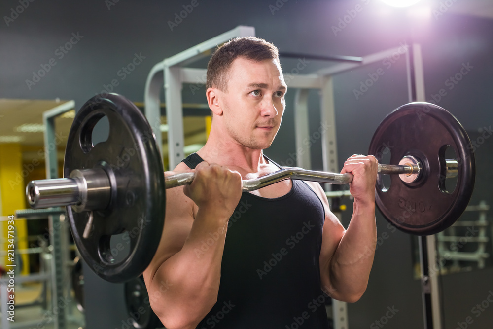 Powerful bodybuilder doing the exercises with barbell. Strength and motivation. Powerful bodybuilder doing the exercises with barbell. Strength and motivation.