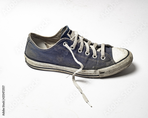 Dirty trainer canvas shoe on white background