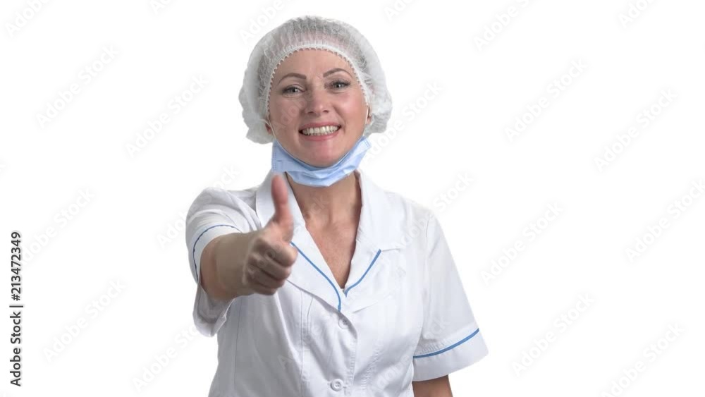 Female doctor showing thumb up. Portrait of positive smiling female surgeon showing sign ok raising thumb up on white background. Female doctor showing thumb up. Portrait of positive smiling female surgeon showing sign ok raising thumb up on white background.