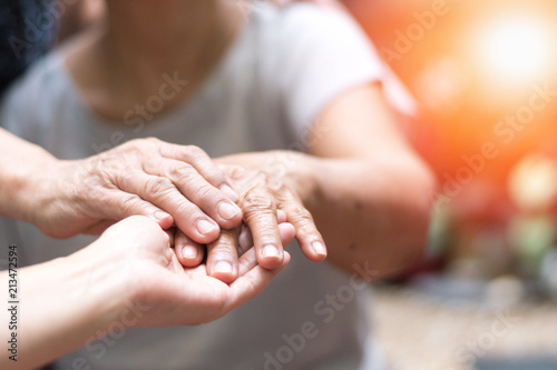 Caregiver, carer hand holding elder hand woman in hospice care. Philanthropy kindness to disabled concept.Public Service Recognition Week photo