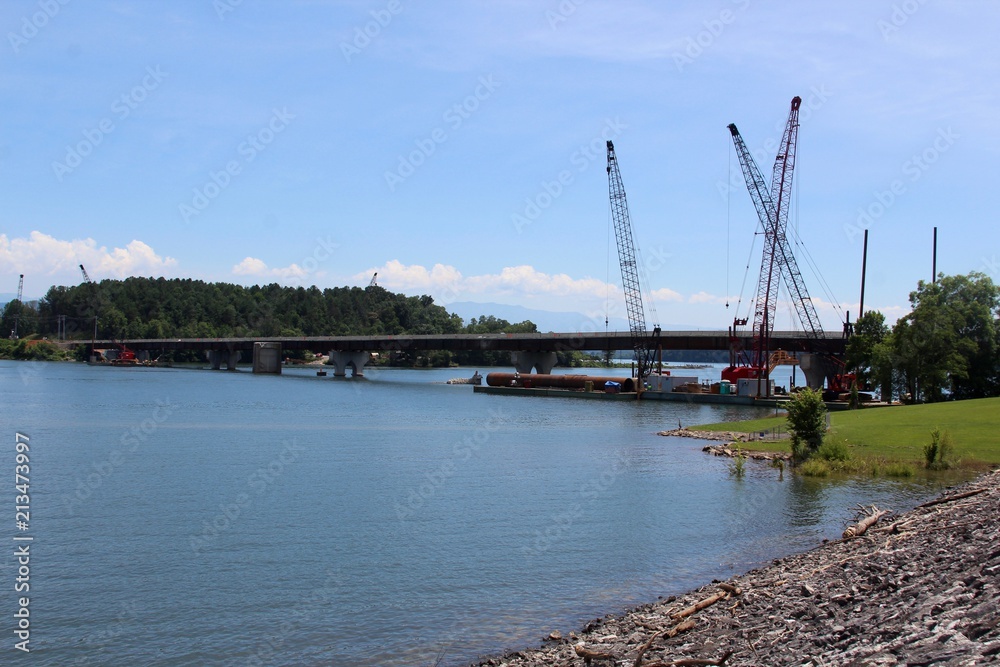 The construction work on the bridge over the lake water.