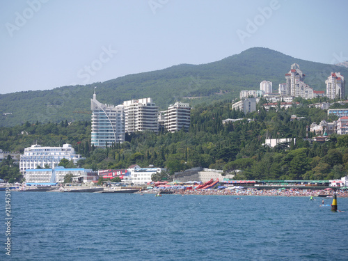 high tall buildings on the background of the mountains near the beach and the pier