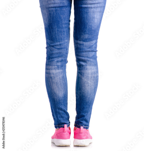 Woman's legs blue denim pink sneakers on white background isolation