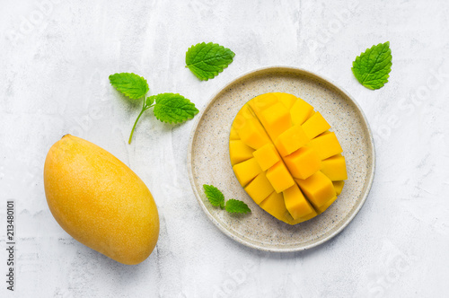 Healthy breakfast. Sliced yellow thai mango fruit on plate. Top view. Concrete background.