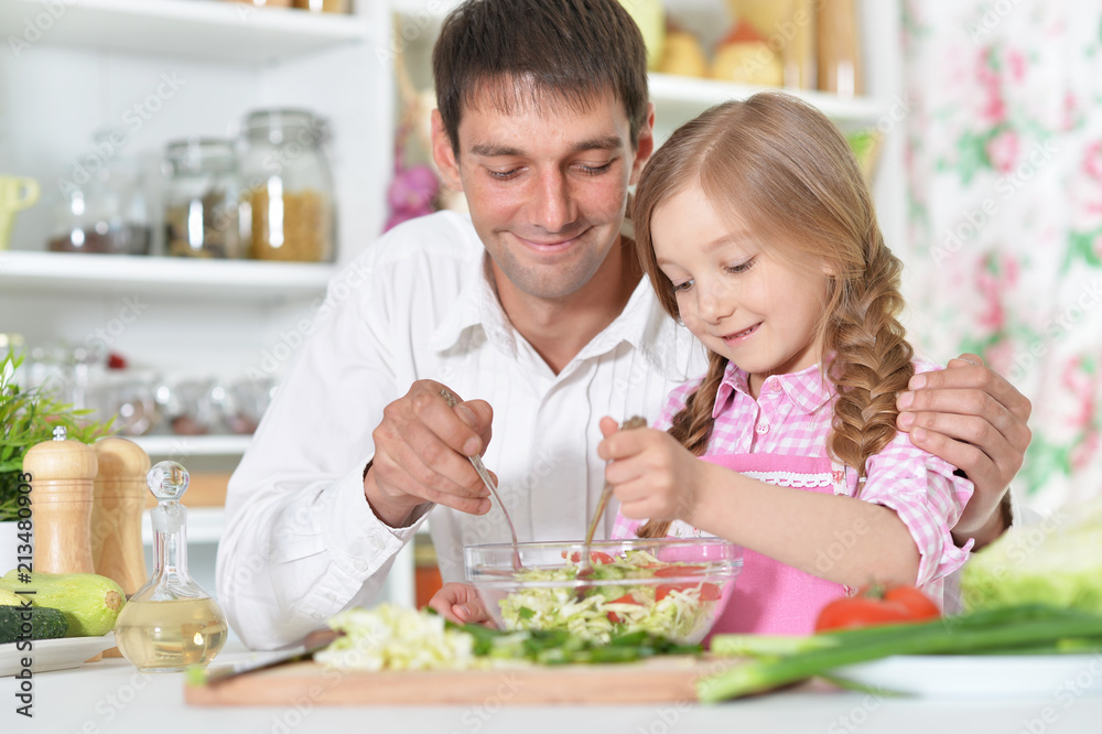 Father and daughter preparing salad Father and daughter preparing salad