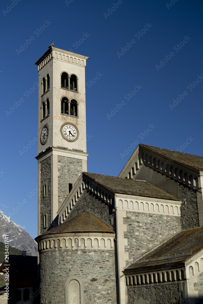 stone church with clock tower in small village isolaccia near bormio, italy