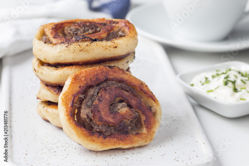 Fried savoury cottage cheese pies with minced meat on a white board, served with yogurt, horizontal