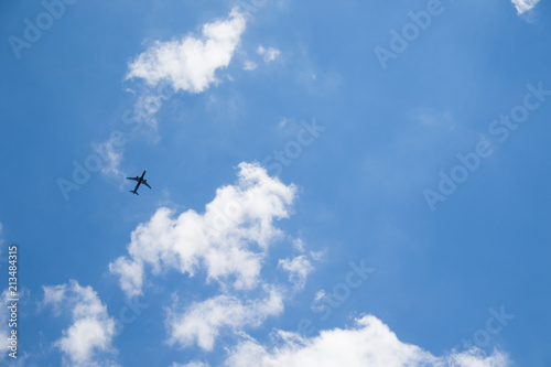 Image of flying airplane in clear sky with sun at background