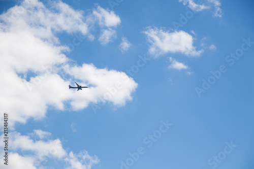 Image of flying airplane in clear sky with sun at background