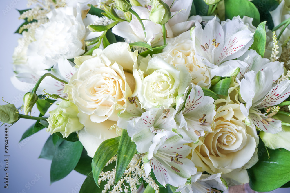 Obraz premium beautiful wedding bouquet with white roses and other flowers on wooden background with 2 wooden pigeons