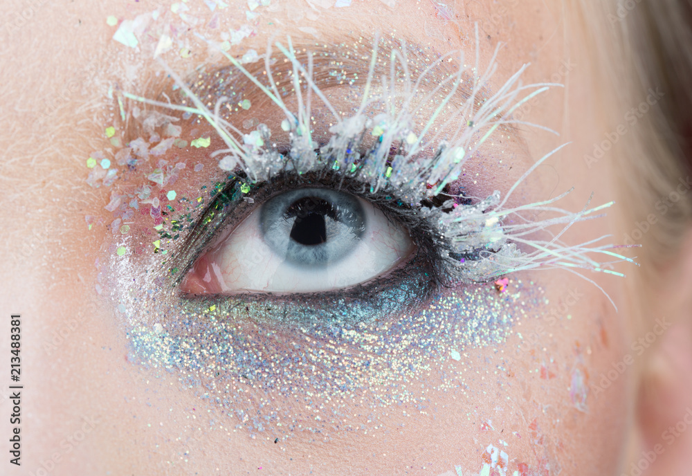 Frosty professional make up for winter fashionable photo session. White  mascara and sparckles on eyelashes. Blue