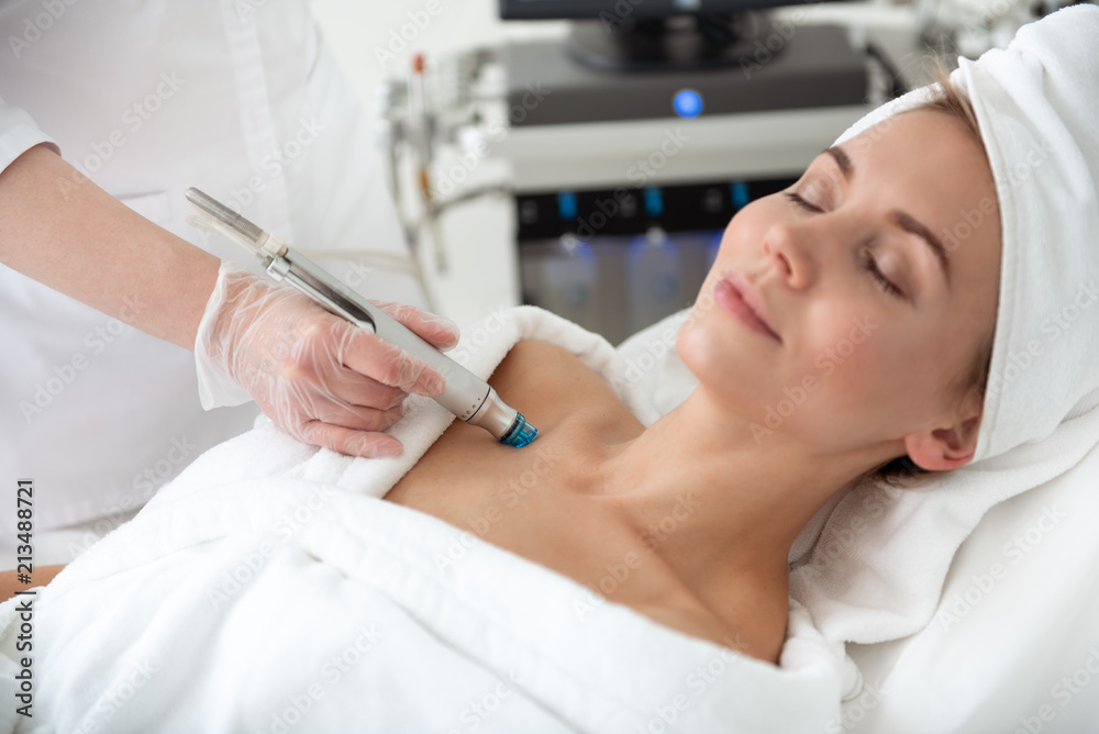 Outgoing lady having pleasure while getting rejuvenating facial massage in beauty clinic Outgoing lady having pleasure while getting rejuvenating facial massage in beauty clinic