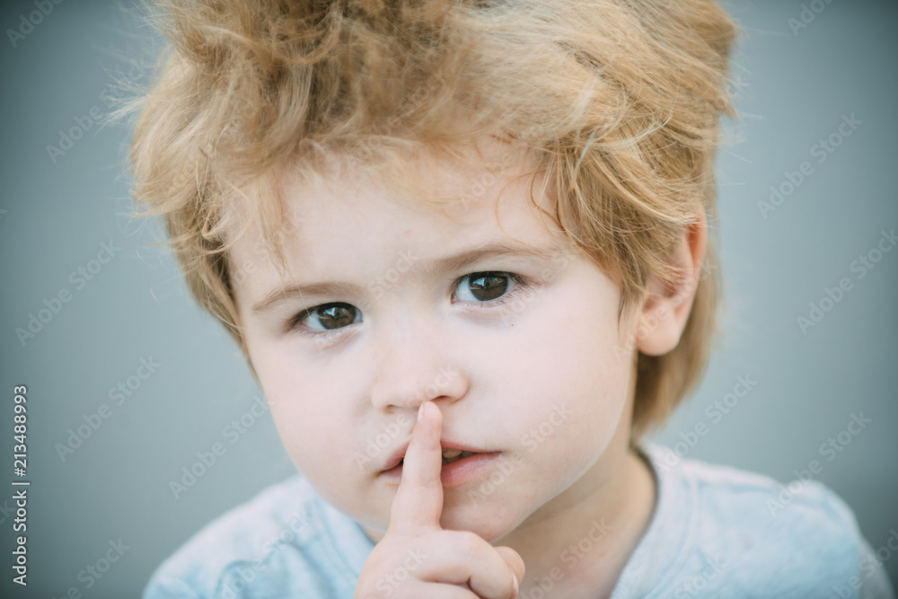 Boy with finger on lips making a silent gesture. Please be quiet. Smart cute young boy with his finger over his lips being quiet. Little boy showing silence symbol gesture. Secret young kid guy Boy with finger on lips making a silent gesture. Please be quiet. Smart cute young boy with his finger over his lips being quiet. Little boy showing silence symbol gesture. Secret young kid guy