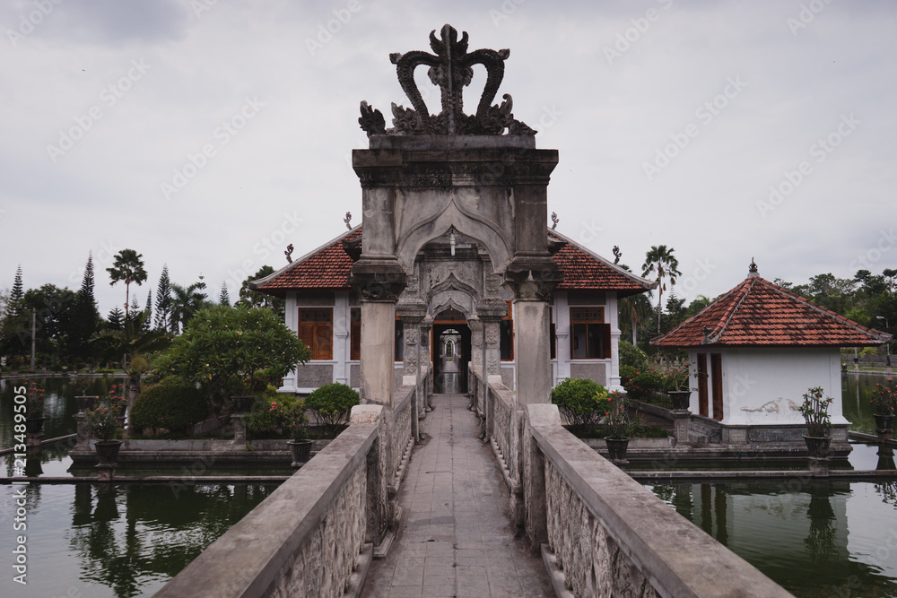 stone bridge in historical Bali hindu temple, surrounded by water