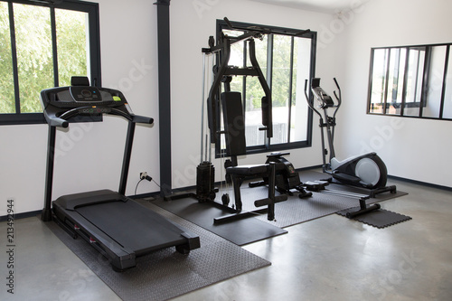 Private gym at home interior with different sport exercise equipment