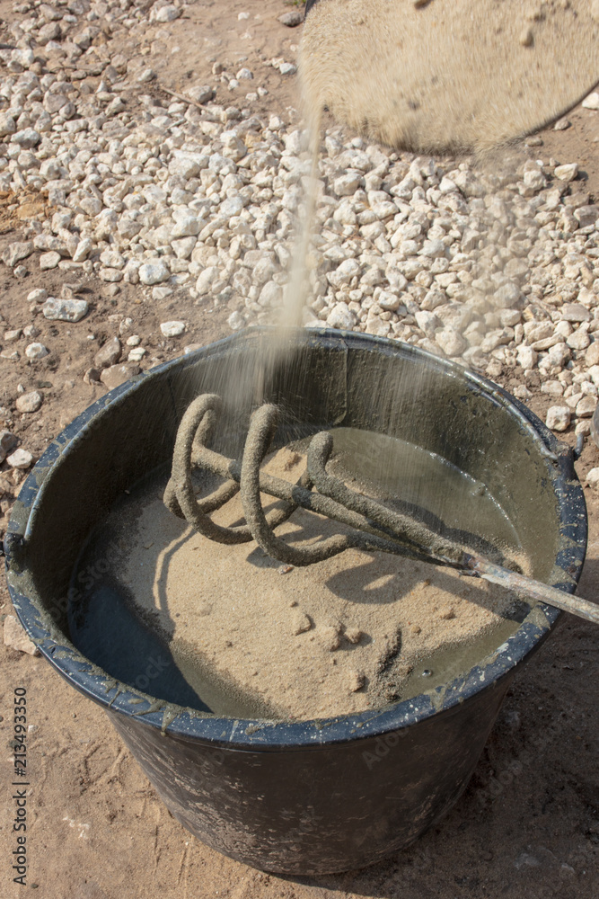 The worker mixes the concrete mixture at the construction site The worker mixes the concrete mixture at the construction site