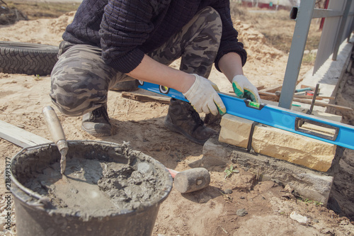 The worker lays bricks on the construction site