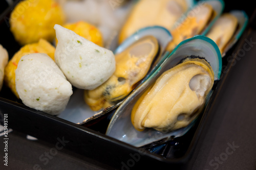 Mixed ingredients on tray including mussel and meatball photo