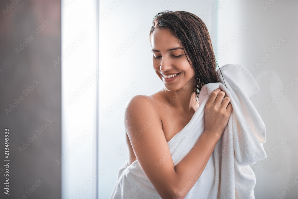 Portrait of beaming female wiping head with towel. She gesticulating hands Portrait of beaming female wiping head with towel. She gesticulating hands