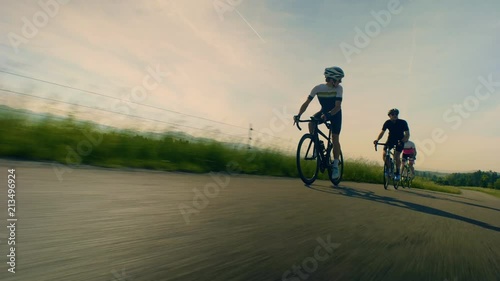 Close up, low angle, tracking shot of cyclists on countryside road photo